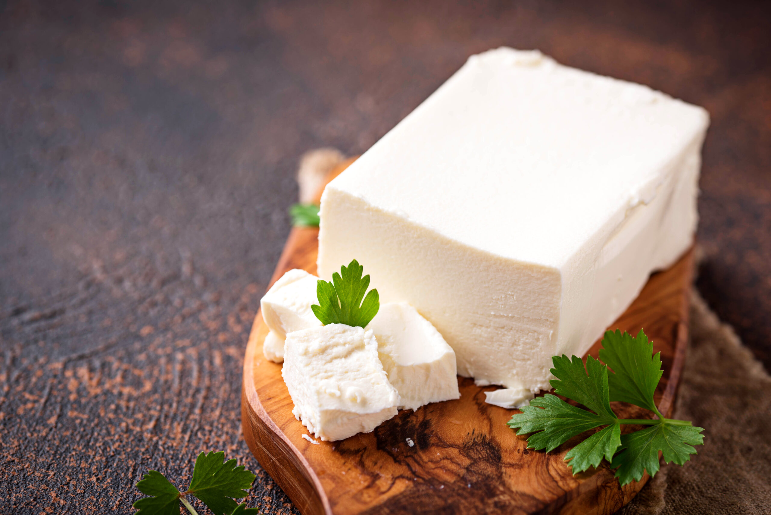 Feta cheese on rusty background. Selective focus